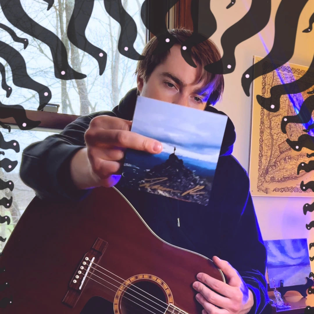 Man holding a signed CD surrounded by decorative elements and a guitar.